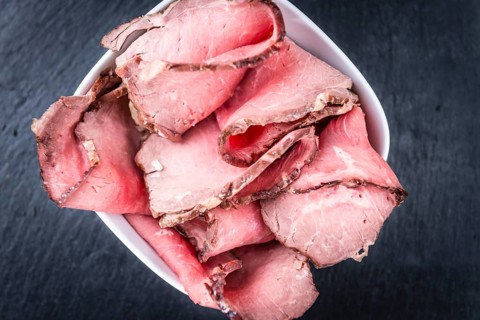 Portion of sliced Roastbeef on a slate slab (selective focus)