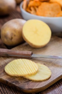 Rippled Potato Chips (selective focus) on an vintage wooden table