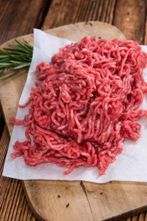 Portion of Minced Meat on an old wooden table (close-up shot)
