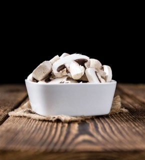 Portion of white Mushrooms (close-up shot) on vintage wooden background