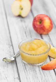 Homemade Applesauce (selective focus, close-up shot) on vintage background with some fresh fruits