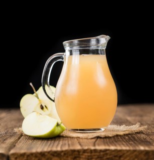 Apple Juice on an old wooden table as detailed close-up shot (selective focus)