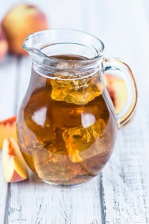 Ice Tea (Peach) on an old wooden table (selective focus, close-up shot)