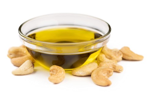 Portion of Cashew Oil isolated on white background (selective focus)