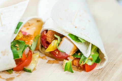 Chicken Wrap (detailed close-up shot, selective focus) on wooden background
