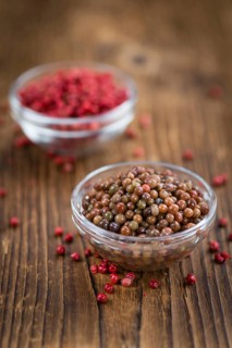 Preserved Pink Peppercorns on a vintage background as detailed close-up shot, selective focus