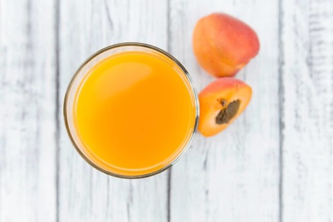 Homemade Apricot Juice on an wooden table (selective focus) as detailed close-up shot