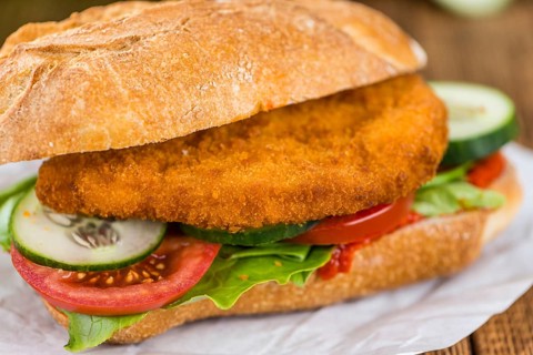 Old wooden table with a Chicken Schnitzel (selective focus, close-up shot)