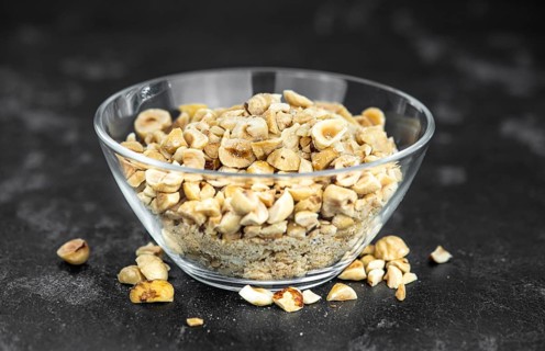 Freshly chopped Hazelnuts as detailed close up shot (selective focus)