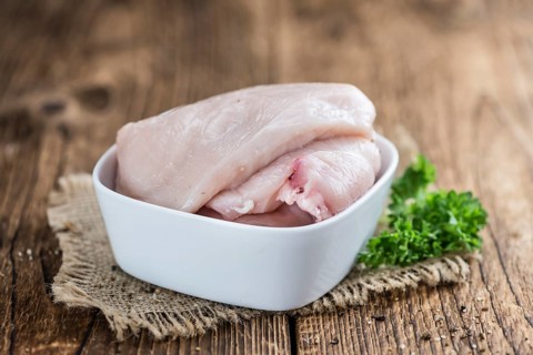Wooden table with chicken cutlet (detailed close-up shot)