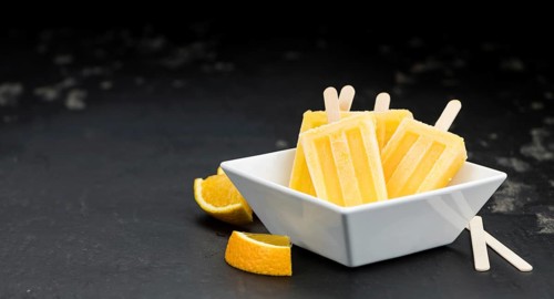 Some homemade orange popsicles on a vintage background (selective focus, close-up shot)