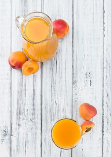 Homemade Apricot Juice on an wooden table (selective focus) as detailed close-up shot