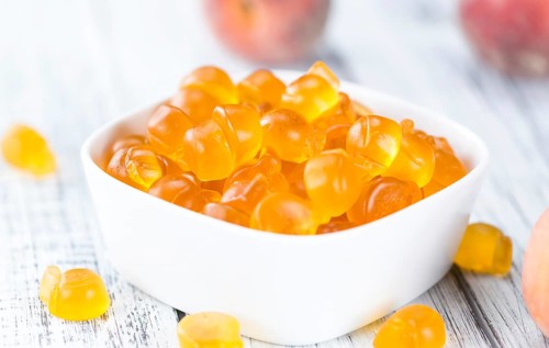 Gummy Peaches (detailed close-up shot) on an old wooden table