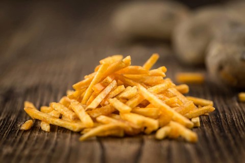Potato Sticks (close-up shot, selective focus) on an old wooden table