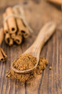 Cinnamon Powder as high detailed close-up shot on a vintage wooden table (selective focus)