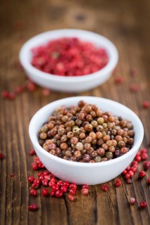 Fresh made Pink Peppercorns (preserved) on an old and rustic wooden table, selective focus,