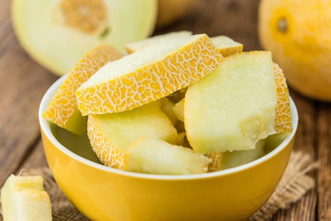 Honeydew Melon on an old wooden table as detailed close-up shot (selective focus)