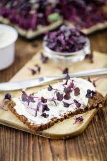 An old wooden table with healthy food (slice of bread, cream cheese and fresh cutted cress),