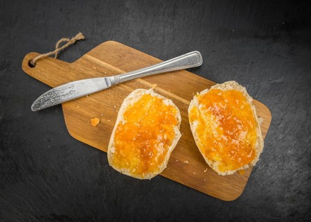 Portion of Peach Jam on a rustic slate slab, selective focus, close-up shot