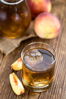 Ice Tea (Peach) on an old wooden table (selective focus, close-up shot)