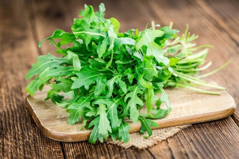 Fresh Arugula (selective focus) as detailed close-up shot on vintage background