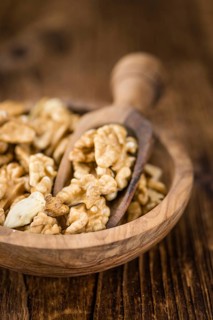 Cracked Walnuts as high detailed close-up shot on a vintage wooden table (selective focus)