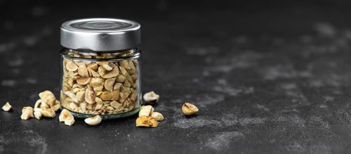 Chopped Hazelnuts on rustic background as close up shot (selective focus)