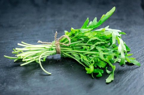 Fresh Arugula (selective focus) as detailed close-up shot on vintage background