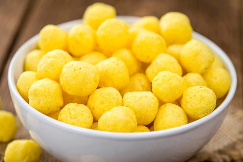 Cheese Balls on an old wooden table as detailed close-up shot (selective focus)