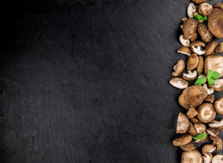 Portion of Raw Shiitake mushrooms on a rustic slate slab, selective focus, close-up shot