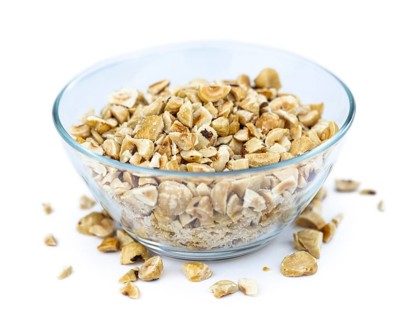 Freshly chopped Hazelnuts as detailed close up shot isolated on white background (selective focus)