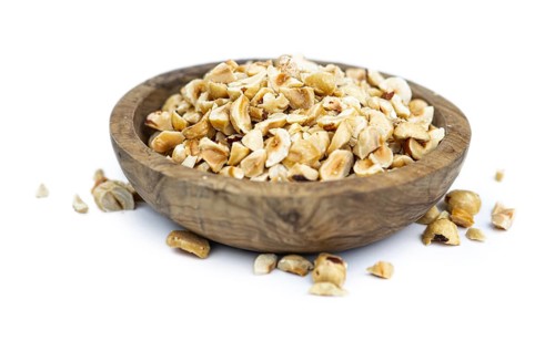 Freshly chopped Hazelnuts as detailed close up shot isolated on white background (selective focus)