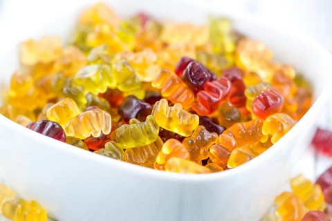Wooden table with Gummy Bears (close-up shot, selective focus)