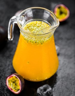 Portion of healthy Maracuja Juice on a slate slab (selective focus)