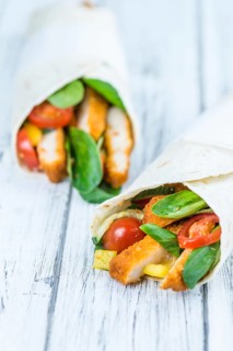 Chicken Wraps on a wooden table as detailed close-up shot (selective focus)