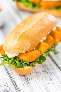 Sandwich with Fish Sticks (selective focus) on an old wooden table