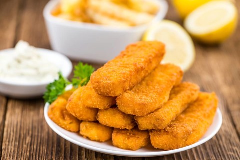 Fisch Sticks (close-up shot) on an old wooden table (selective focus)