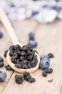 Dried Blueberries as high detailed close-up shot on a vintage wooden table, selective focus