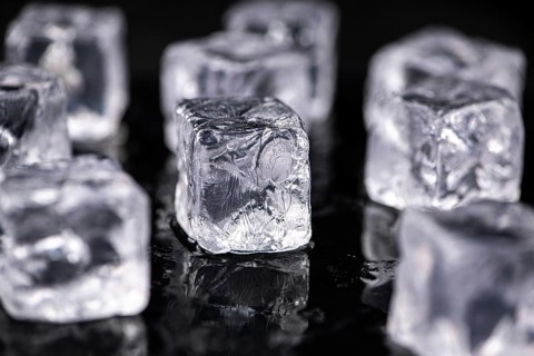Ice Cubes on dark background as detailed close-up shot, selective focus