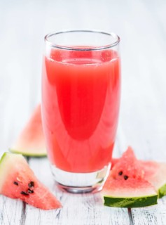 Homemade Watermelon Smoothie on an wooden table (selective focus) as detailed close-up shot