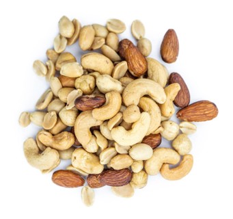 Portion of roasted nuts isolated on white background as close up shot (selective focus)