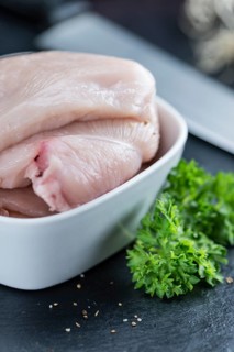 Raw Chicken Cutlet on a slate slab (detailed close-up shot)