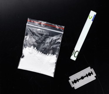 Dark plate with a portion of Cocaine as close-up shot