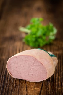 Liverwurst (German cuisine) as high detailed close-up shot on a vintage wooden table (selective