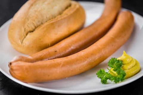 Sausages (Frankfurter) on a vintage slate slab (close-up shot, selective focus)