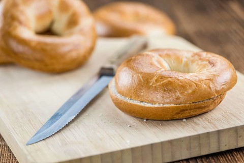 Fresh made plain Bagel (selective focus) on vintage background (close-up shot)