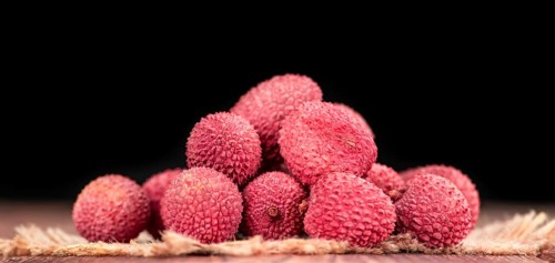 Litchis on an old wooden table as detailed close-up shot (selective focus)