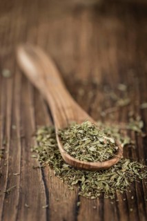 Old wooden table with dried Stevia leaves (close-up shot, selective focus)