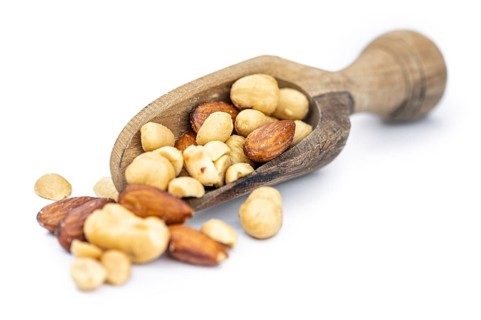 Fresh roasted nuts isolated on white background as close up shot (selective focus)