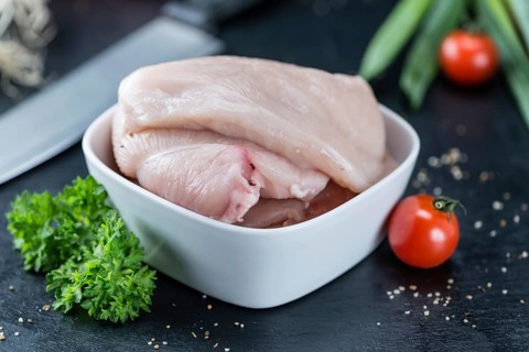 Slate slab with raw Chicken Cutlet (close-up shot)
